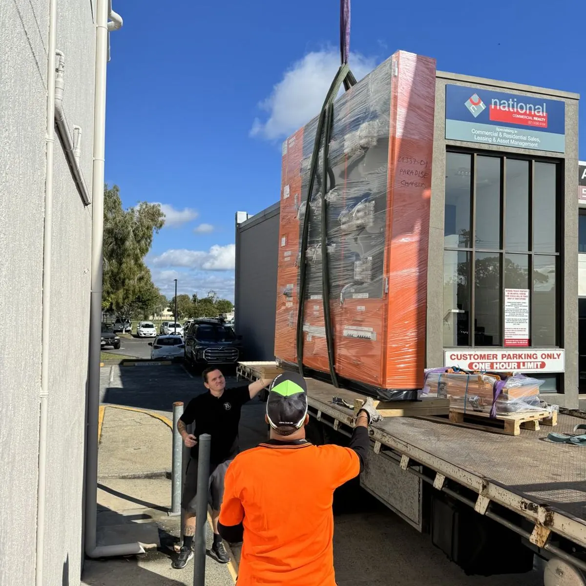 A commercial switchboard being lifted off a truck by crane