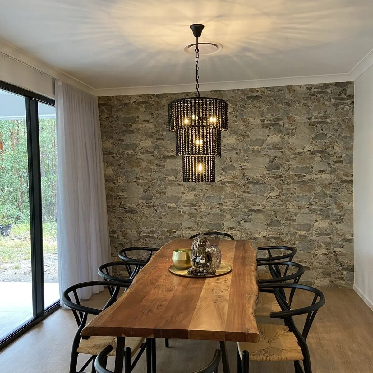 A beaded pendant chandelier hanging over a timber dining table