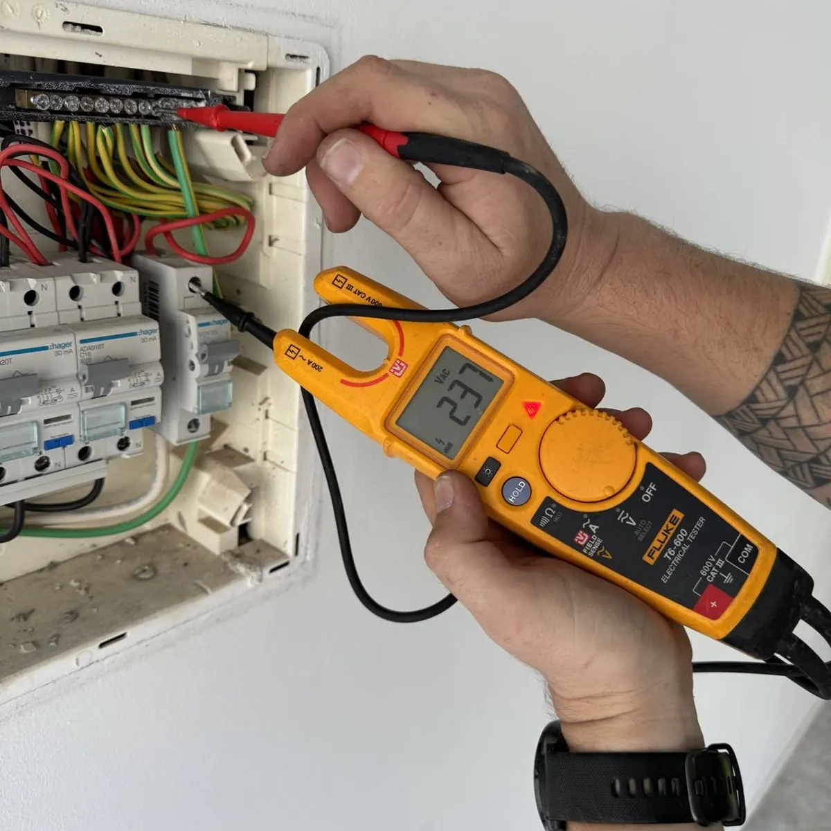 Testing voltage at a switchboard with a Fluke electrical tester