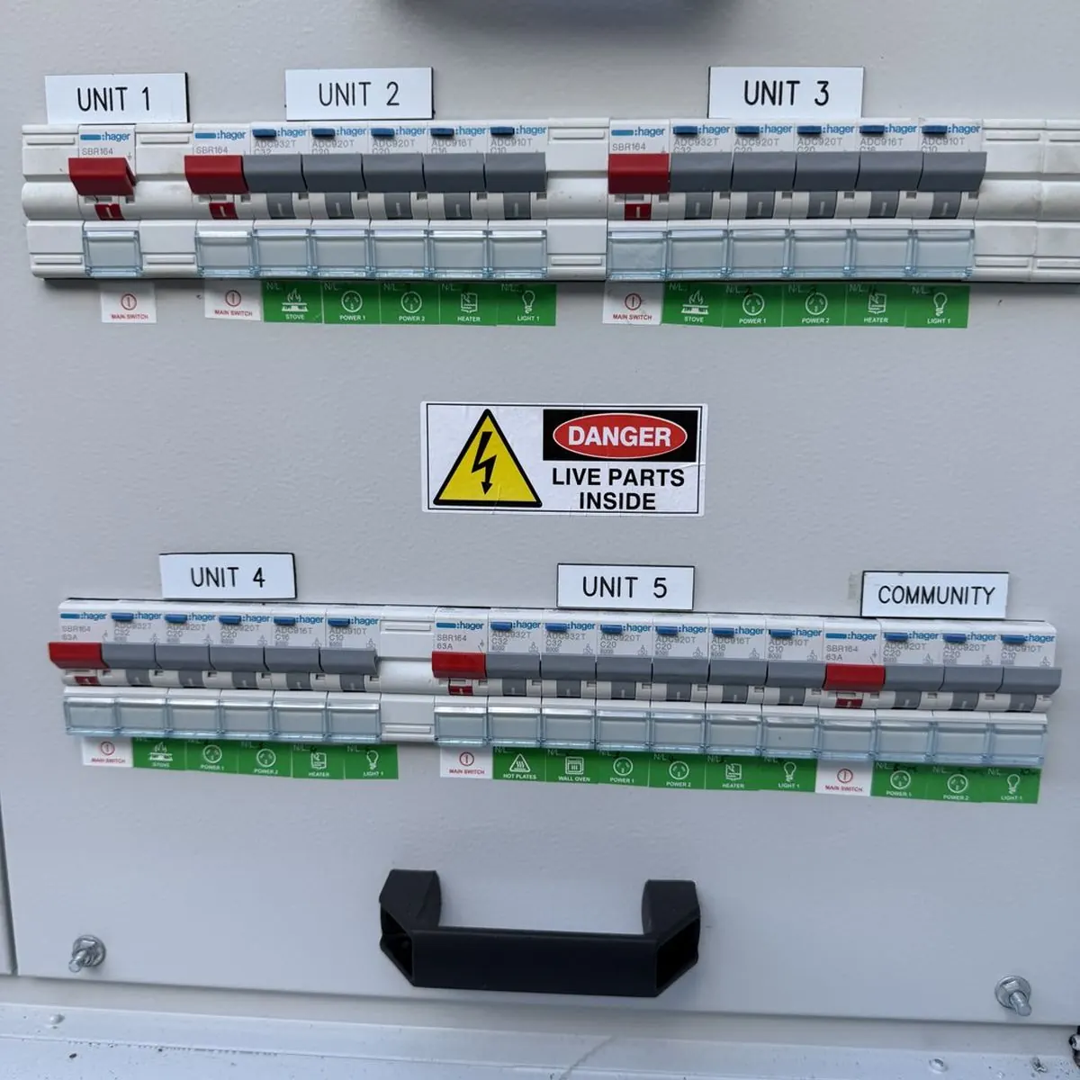 A switchboard with each circuit labelled by unit, from Unit 1 to Unit 5 plus the community supply